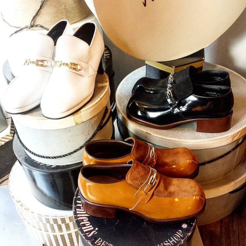 Three pairs of vintage platform shoes displayed on top of various hat boxes.